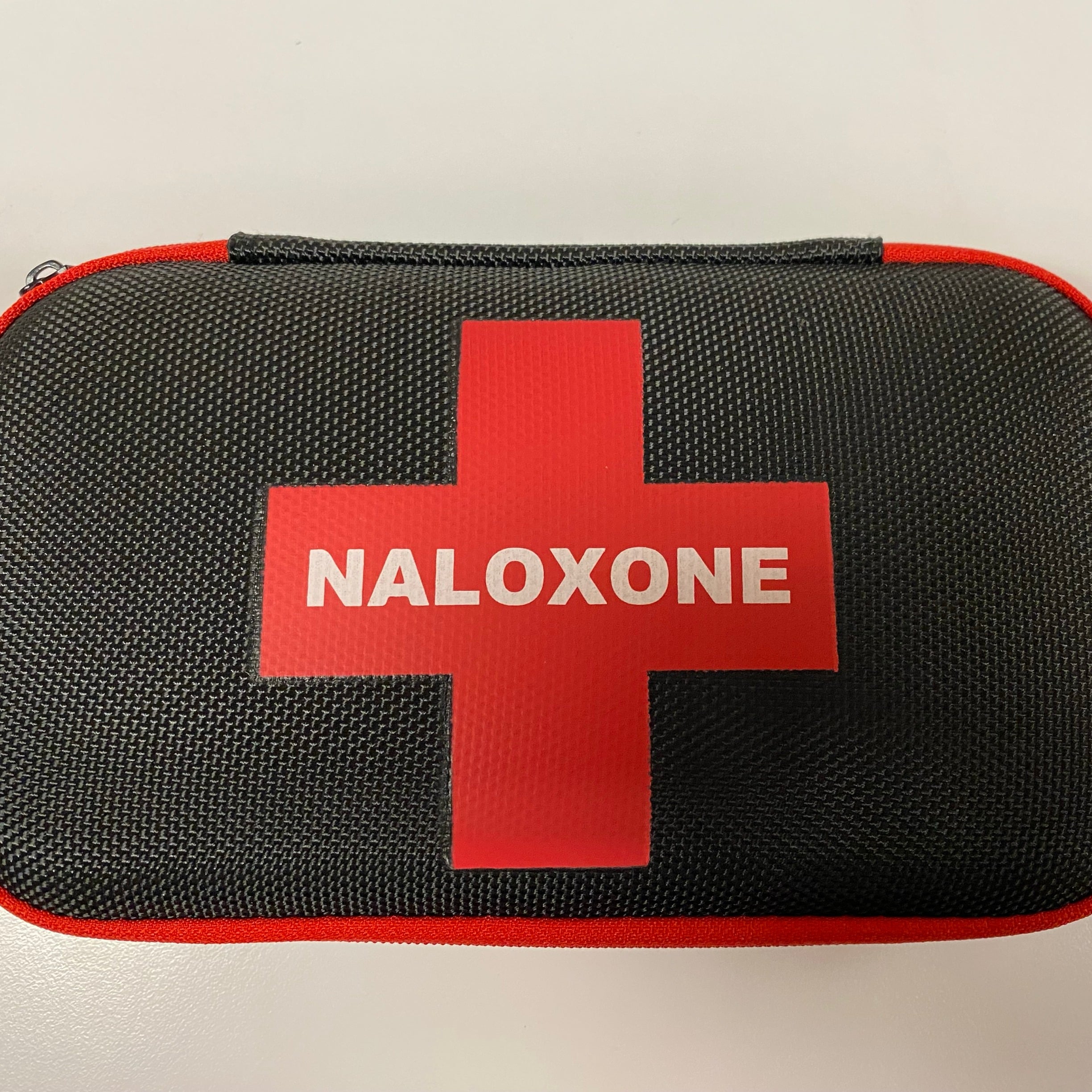 Naloxone kit with red cross on a table