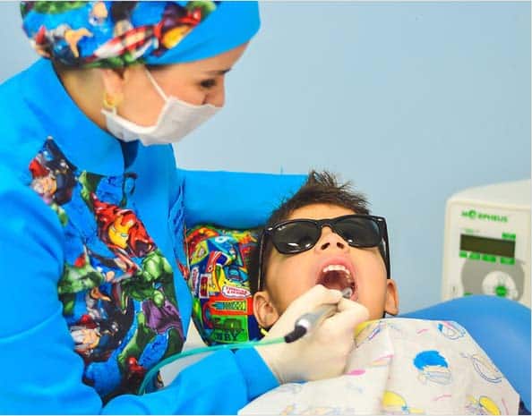 A dental professional cleans a young child's teeth.