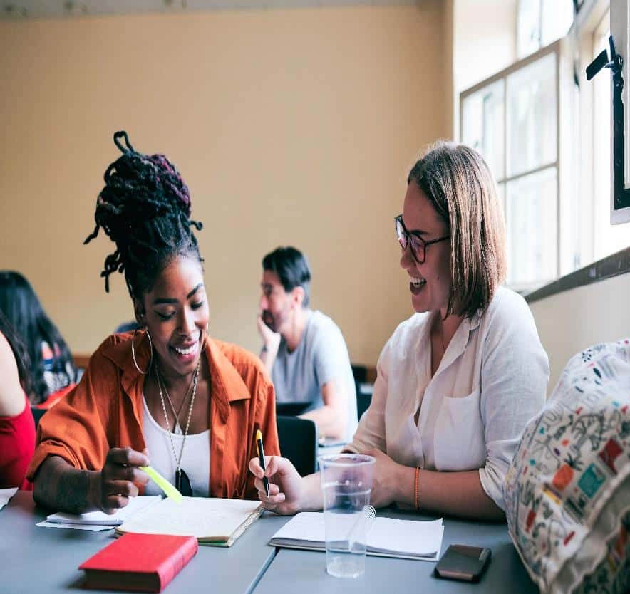 Two individuals at a table going over some papers.